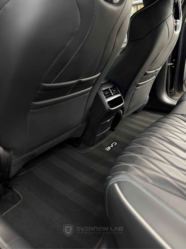 Immaculate BYD electric car interior after professional detailing in Sydney, featuring striped carpets and clean leather seats.