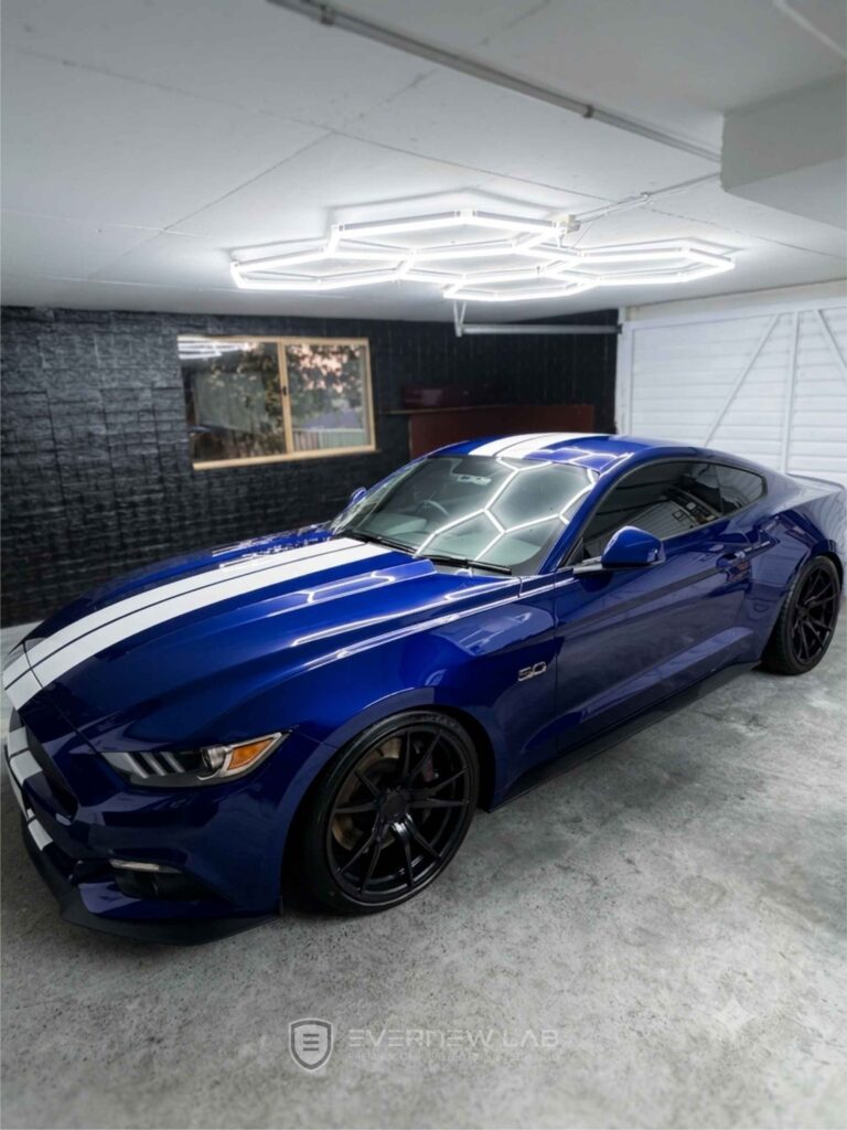 Blue Ford Mustang GT with white racing stripes after show-car paint correction in Sydney.
