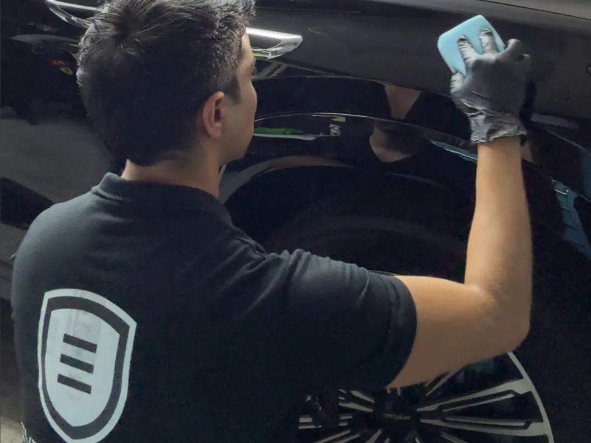 Alex applying ceramic coating with a suede applicator on a black car